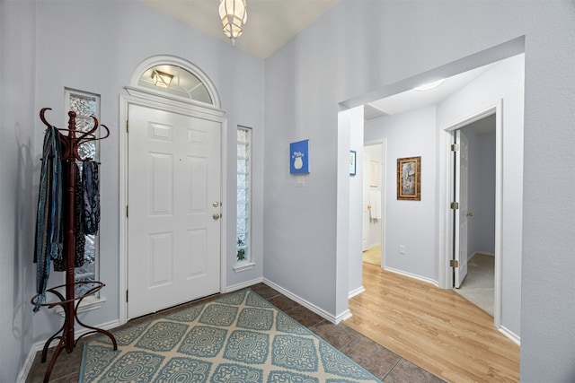 foyer entrance with baseboards and wood finished floors