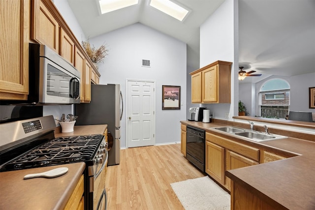 kitchen with a skylight, visible vents, appliances with stainless steel finishes, light wood-style floors, and a sink