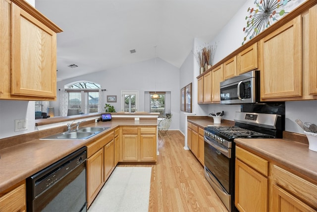 kitchen with visible vents, lofted ceiling, stainless steel appliances, light wood-style floors, and a sink