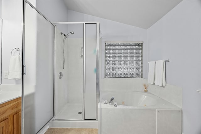 full bathroom with a stall shower, lofted ceiling, vanity, and a tub with jets