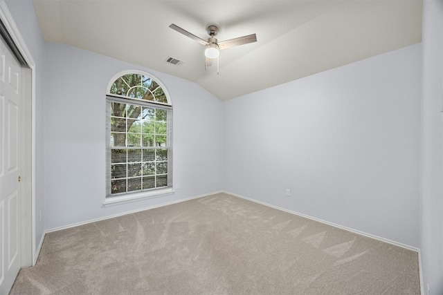 unfurnished room featuring baseboards, visible vents, a ceiling fan, light colored carpet, and lofted ceiling