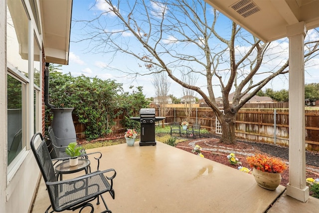 view of patio / terrace with a fenced backyard, a grill, and visible vents