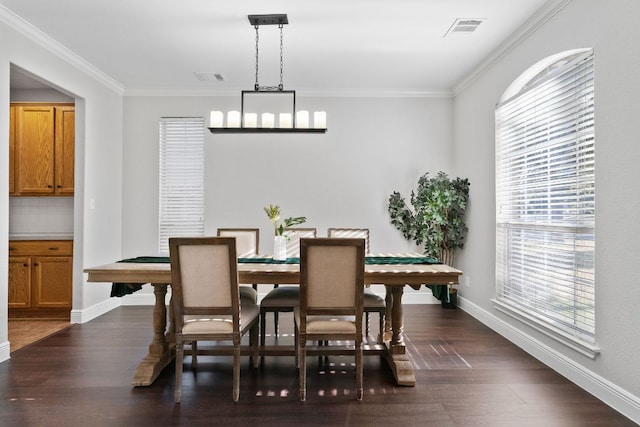 dining area featuring dark wood-style flooring, visible vents, and crown molding