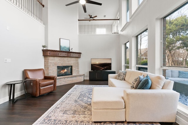 living room with dark wood-type flooring, a fireplace, and baseboards