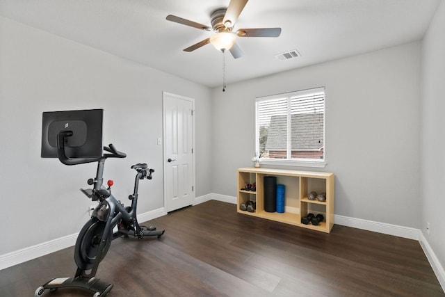 workout area featuring dark wood-type flooring, visible vents, baseboards, and a ceiling fan