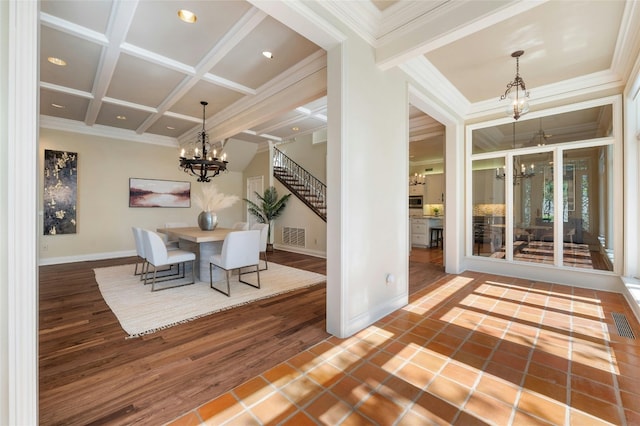 unfurnished dining area featuring a chandelier, coffered ceiling, baseboards, stairs, and ornamental molding