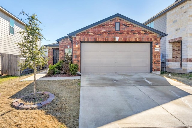 view of front facade featuring driveway, a garage, fence, and brick siding