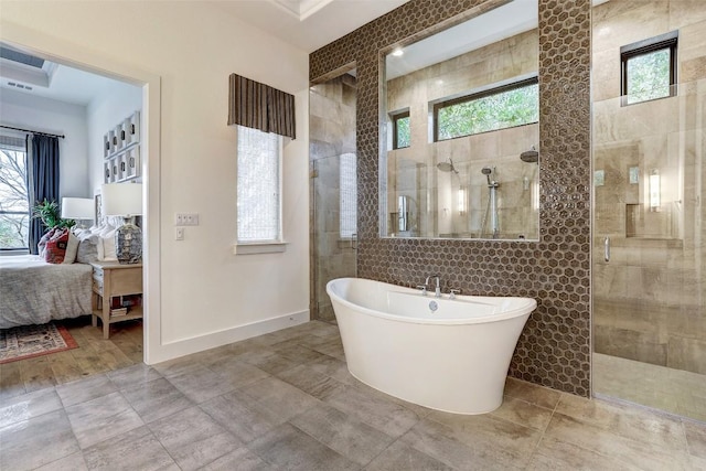 full bath featuring a wealth of natural light, a tile shower, a freestanding bath, and ensuite bathroom