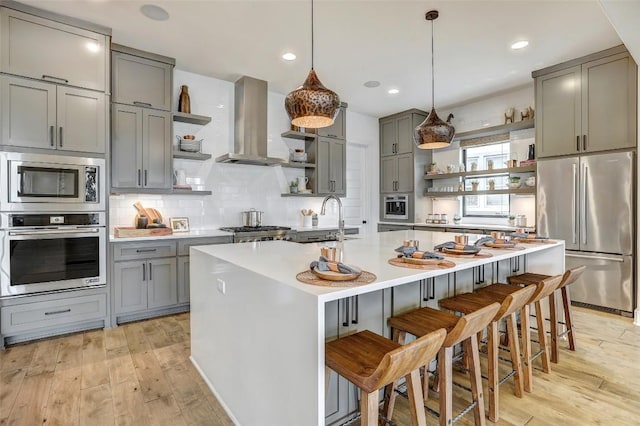 kitchen with open shelves, stainless steel appliances, light countertops, a sink, and extractor fan