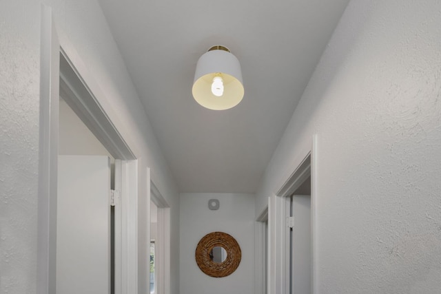 hallway featuring a textured wall