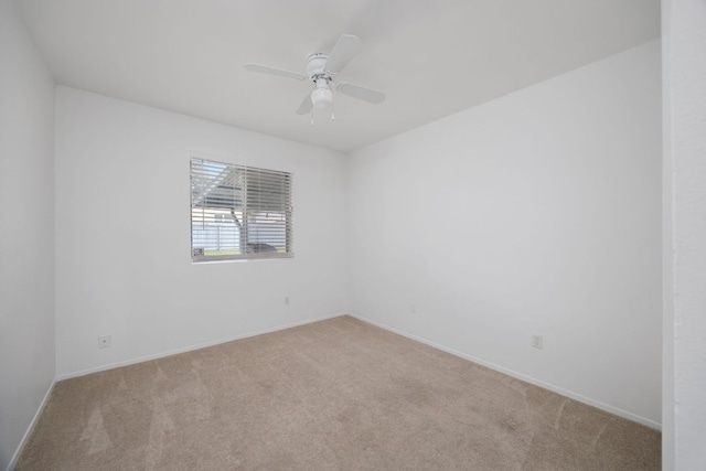 unfurnished room with light carpet, a ceiling fan, and baseboards