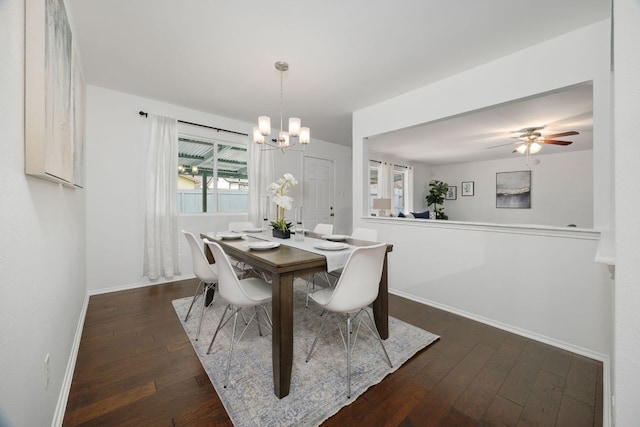 dining area with dark wood finished floors, baseboards, and ceiling fan with notable chandelier