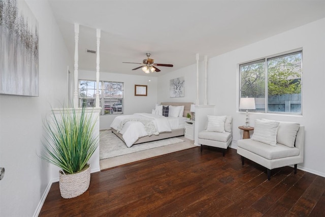 bedroom with baseboards, multiple windows, and hardwood / wood-style floors