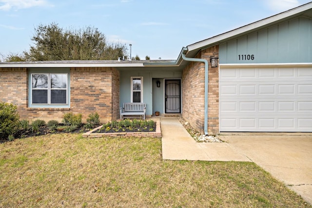 single story home featuring an attached garage, a front lawn, and brick siding