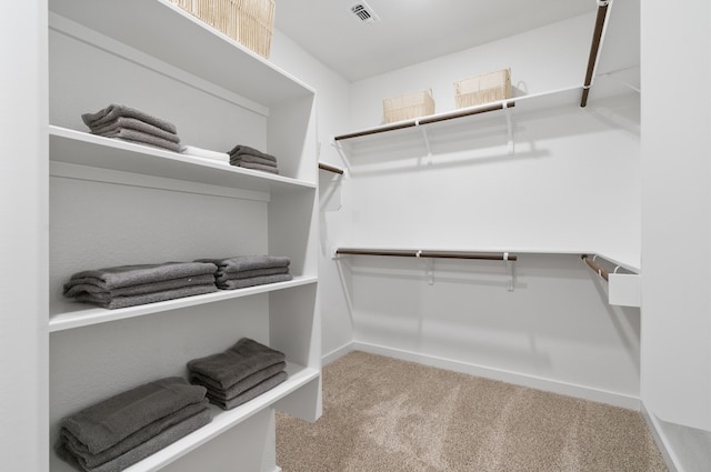 walk in closet with visible vents and carpet