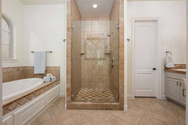 full bathroom featuring a garden tub, tile patterned flooring, a shower stall, and vanity