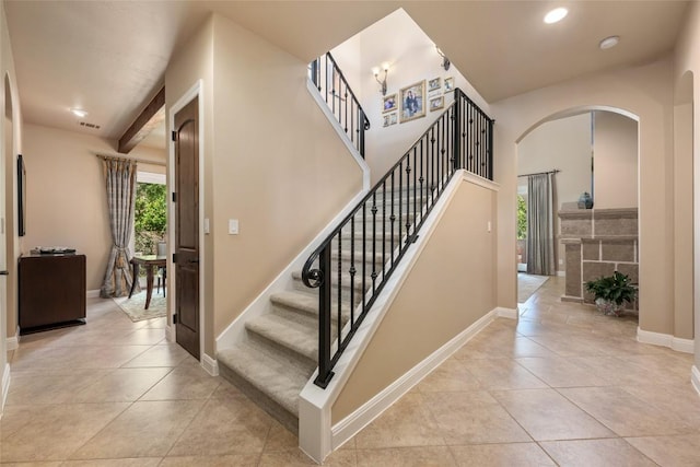 stairs featuring plenty of natural light, baseboards, and tile patterned floors