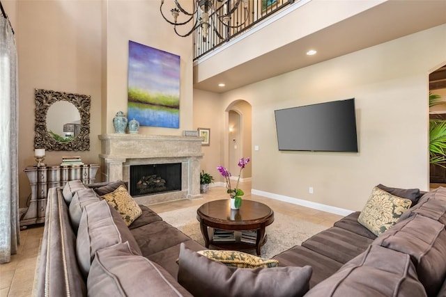5807 City Park Rd Unit 14, Austin, TX 78730 - living area featuring arched walkways, a towering ceiling, baseboards, recessed lighting, and a fireplace