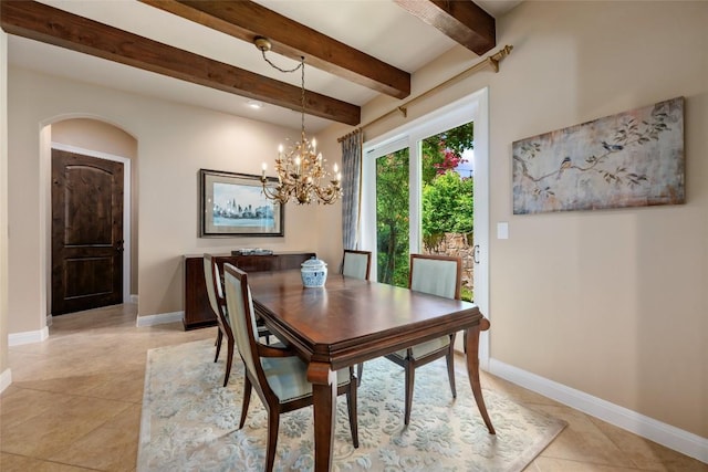 dining room featuring arched walkways, beamed ceiling, light tile patterned flooring, and baseboards