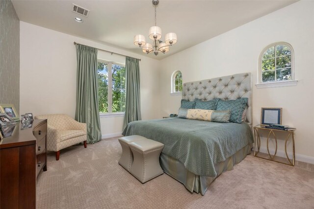 carpeted bedroom with baseboards, multiple windows, visible vents, and a chandelier