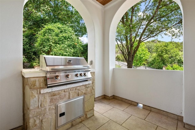 view of patio with exterior kitchen, grilling area, and fence