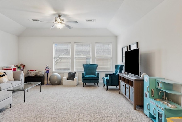 living room featuring lofted ceiling, carpet flooring, visible vents, and a ceiling fan