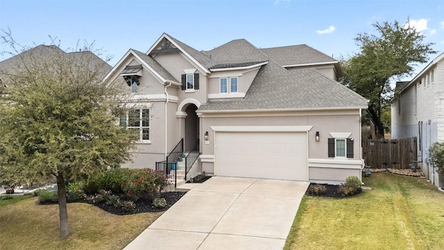 view of front of home with driveway, a front yard, fence, and stucco siding