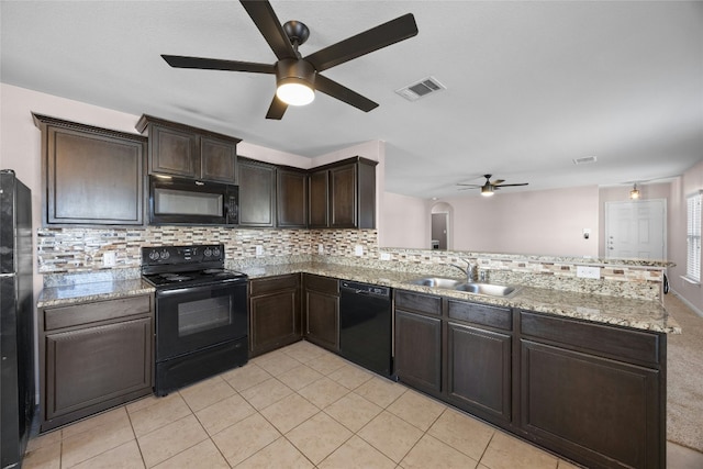 kitchen featuring visible vents, a sink, a peninsula, and black appliances