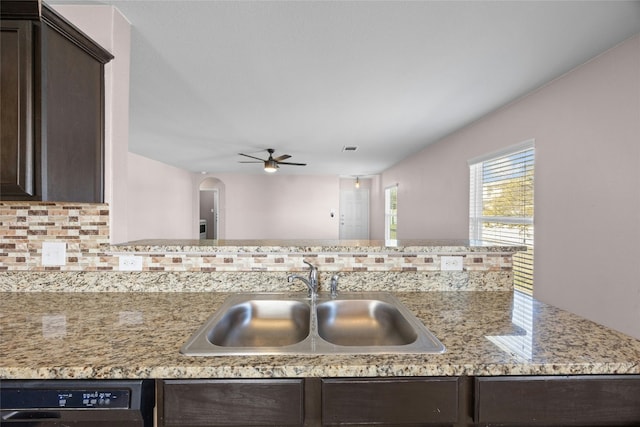 kitchen with tasteful backsplash, black dishwasher, dark brown cabinets, and a sink