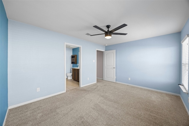 unfurnished bedroom with light colored carpet, connected bathroom, visible vents, and baseboards