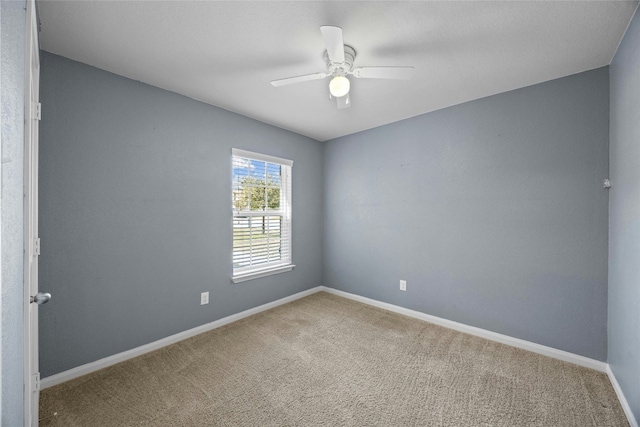 empty room with carpet floors, ceiling fan, and baseboards