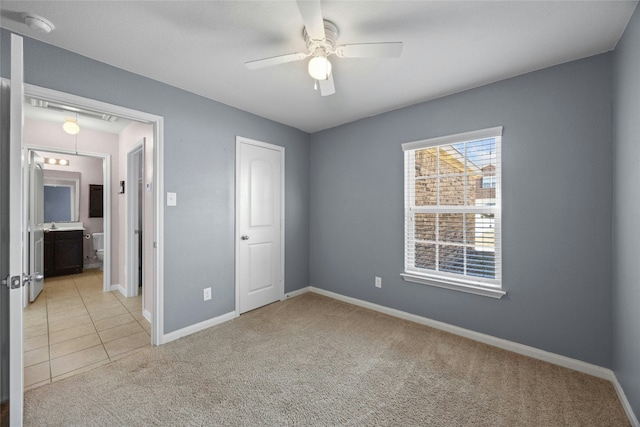 unfurnished bedroom with baseboards, ceiling fan, light tile patterned floors, and light colored carpet