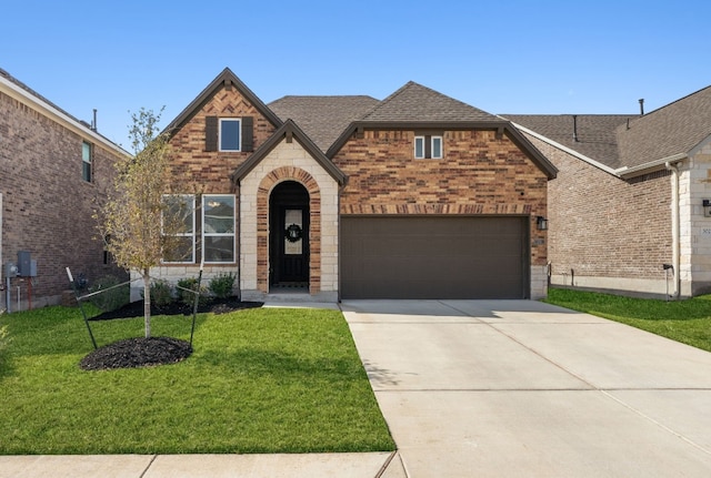 view of front of property with brick siding, a shingled roof, an attached garage, a front yard, and driveway