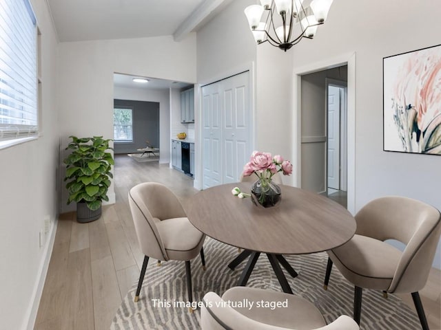 dining area with lofted ceiling with beams, light wood finished floors, baseboards, and a notable chandelier