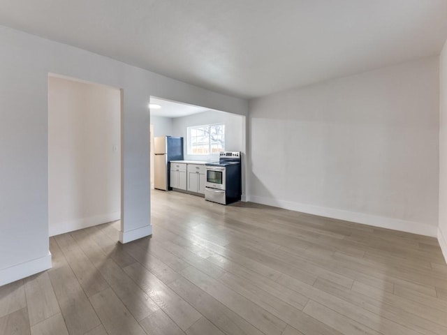 unfurnished living room featuring light wood-style floors and baseboards