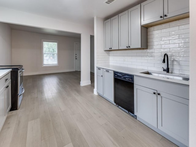 kitchen featuring a sink, stainless steel range with electric cooktop, light countertops, dishwasher, and light wood finished floors