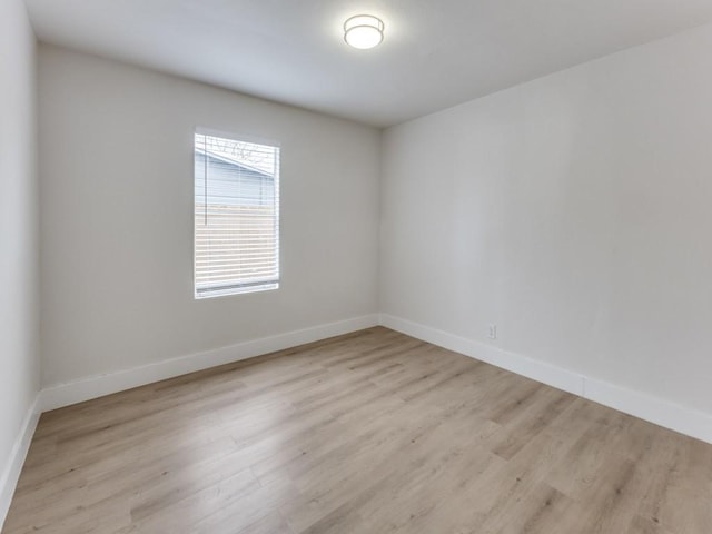 unfurnished room featuring light wood-style flooring and baseboards