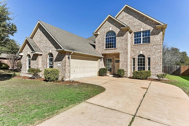 view of front of house featuring an attached garage, driveway, a front lawn, and fence