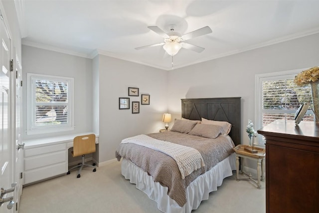 bedroom featuring ceiling fan, light carpet, baseboards, ornamental molding, and built in study area