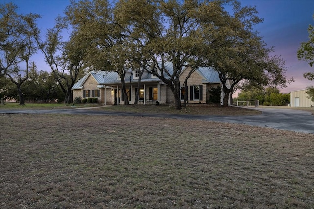 view of front facade featuring a standing seam roof, metal roof, and a lawn