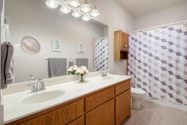 bathroom with double vanity, curtained shower, a sink, and toilet