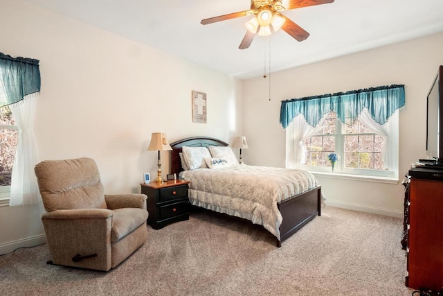 carpeted bedroom with ceiling fan and baseboards