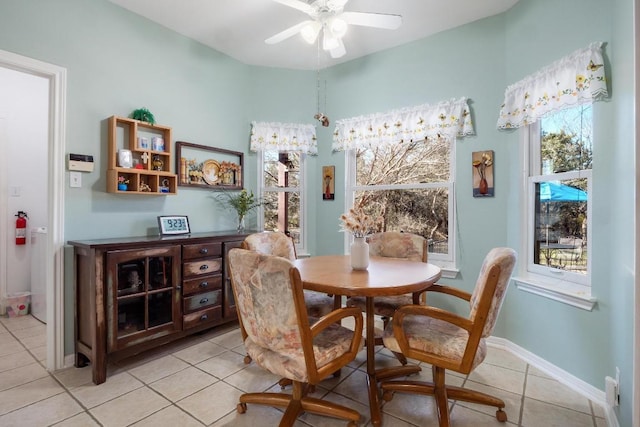 dining space featuring light tile patterned flooring, ceiling fan, and baseboards