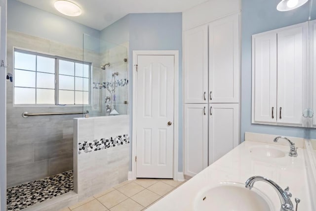 full bathroom featuring a walk in shower, a sink, and tile patterned floors