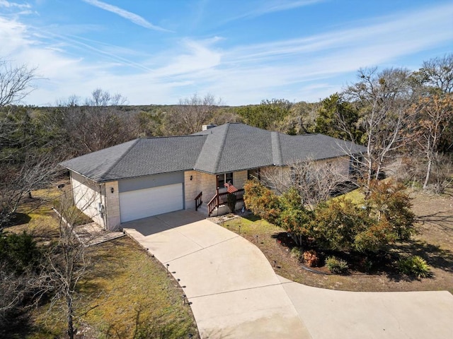 single story home with a garage, a shingled roof, a chimney, and concrete driveway