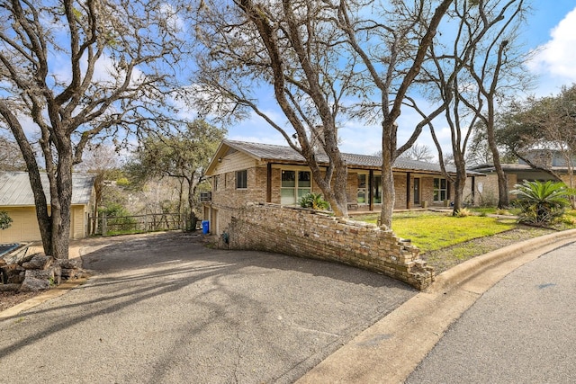 ranch-style house featuring brick siding, a front yard, and fence