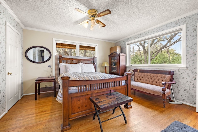 bedroom featuring crown molding, a textured ceiling, light wood finished floors, and wallpapered walls