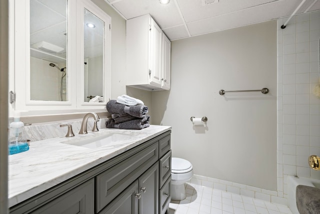 bathroom featuring baseboards, toilet, vanity, tile patterned flooring, and shower / bathtub combination