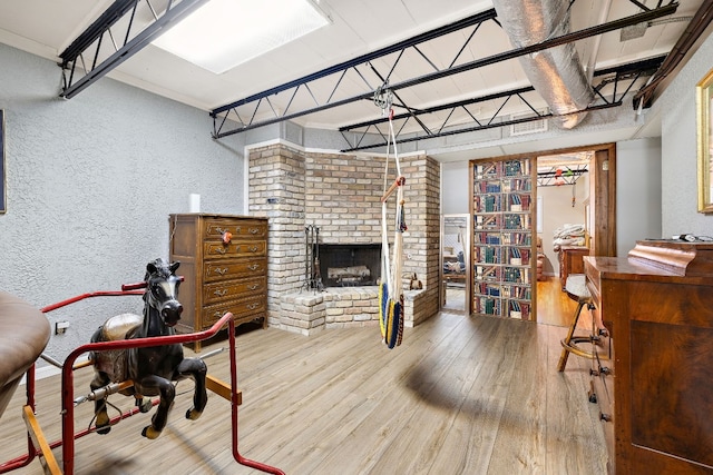 office featuring hardwood / wood-style flooring, a fireplace, and a textured wall