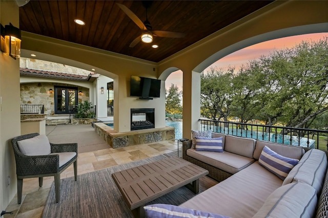 view of patio featuring an outdoor living space with a fireplace and a ceiling fan